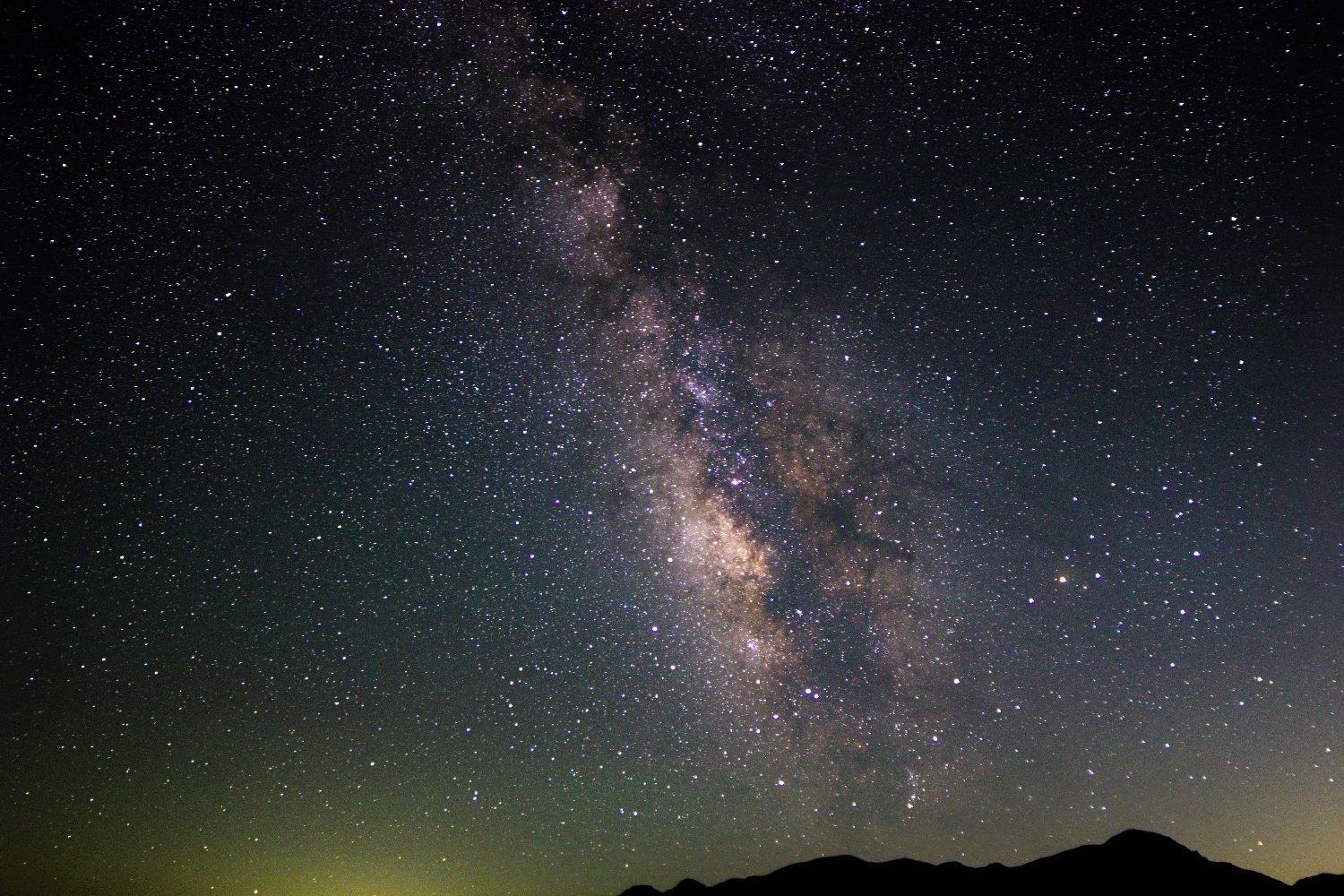 The Milky Way arching over a silhouetted Joshua tree in the Pinto Basin under a deep, star-filled sky